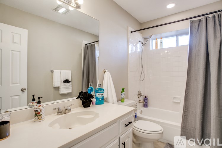 A bathroom with a white sink, toilet, and a mirror.