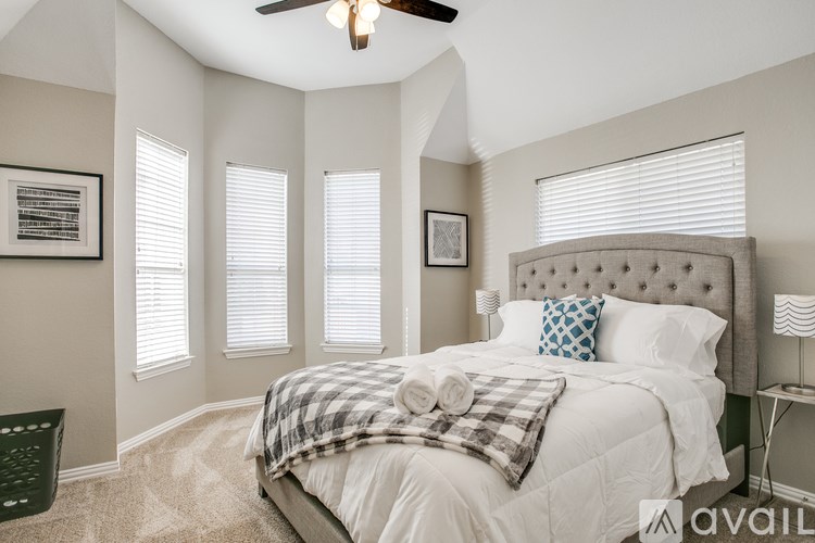 A bedroom with a large bed and a ceiling fan.