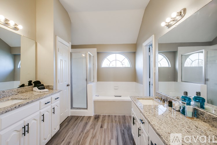 A bathroom with a tub, sink, and mirror.