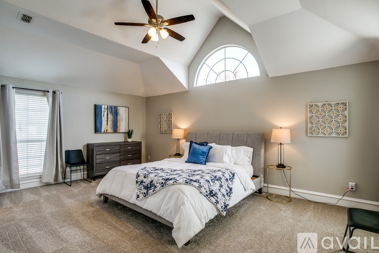 A bedroom with a large bed and a ceiling fan.