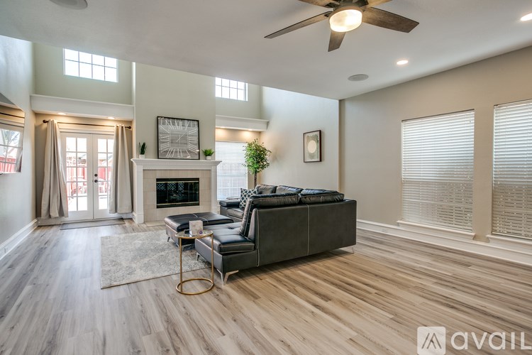 A spacious living room with a grey sofa and a fireplace.