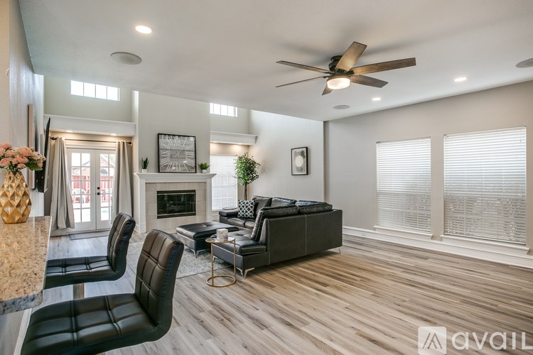 A modern living room with a fireplace and a ceiling fan.