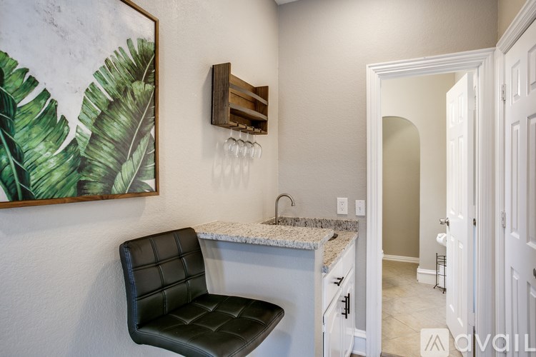A black leather chair sits in front of a marble countertop in a kitchen.