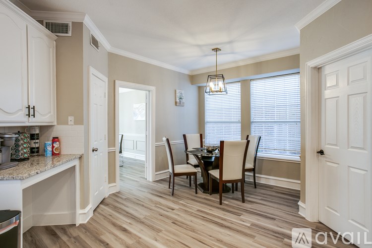 A kitchen with a dining table and chairs.