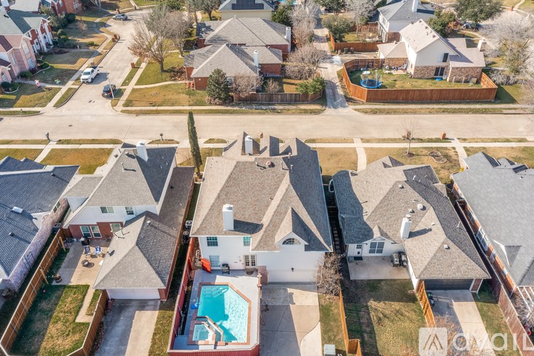 A bird's eye view of a neighborhood with houses and a pool.