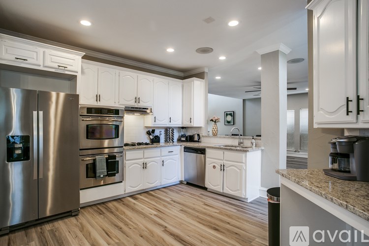 A modern kitchen with stainless steel appliances and white cabinets.