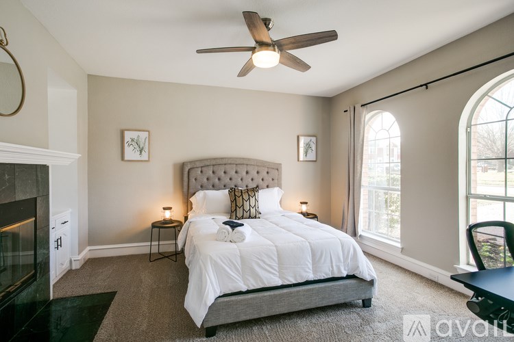 A bedroom with a large bed and a fireplace.