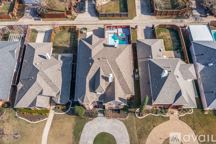 A bird's eye view of a residential area with houses and a swimming pool.
