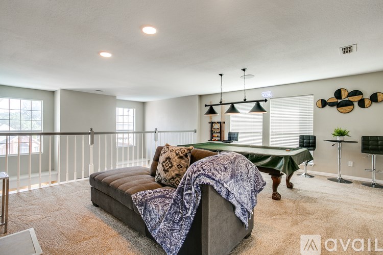 A living room with a sofa and a pool table.