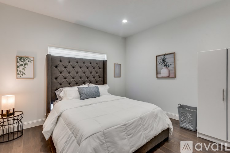 A bedroom with a large bed and a wall-mounted air conditioner unit.