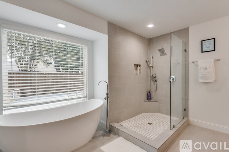 A modern bathroom with a white tub and a walk-in shower.