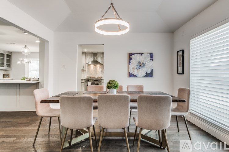 A modern dining room with a large table and chairs.