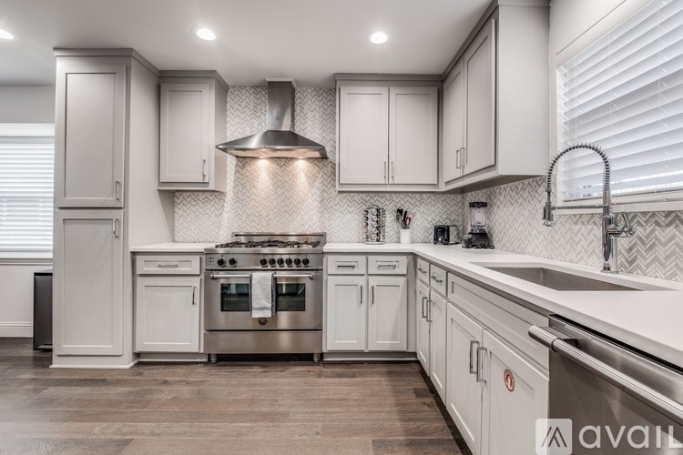 A modern kitchen with a stainless steel oven and white cabinets.