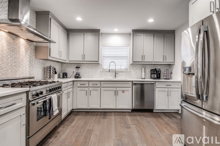 A modern kitchen with stainless steel appliances and white cabinets.