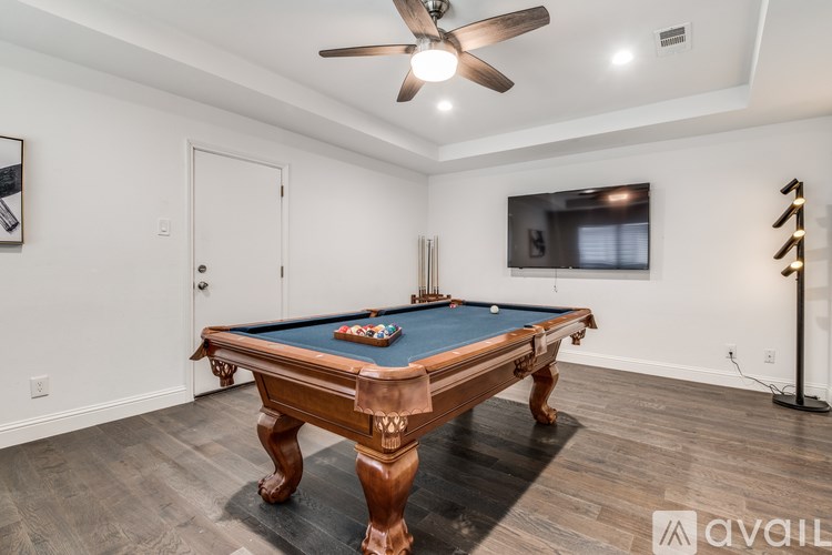 A pool table with a green felt cloth is in the center of the room.