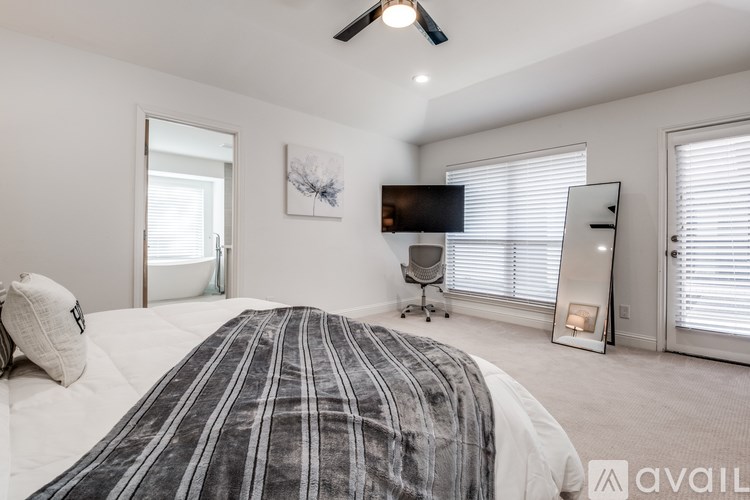 A bedroom with a large bed and a ceiling fan.