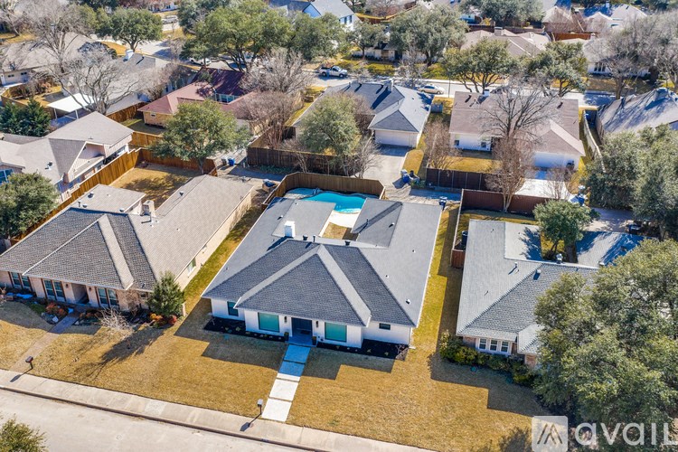 A bird's eye view of a suburban neighborhood with houses and a pool.