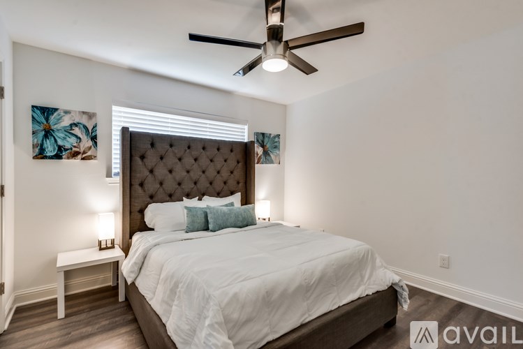 A bedroom with a large bed and a ceiling fan.