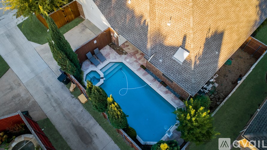 A small pool surrounded by a concrete patio and a brick wall.