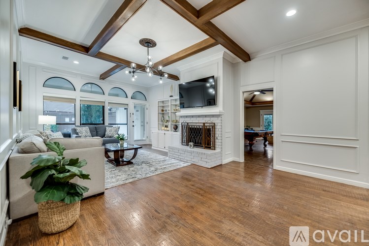 A spacious living room with a fireplace and a ceiling fan.