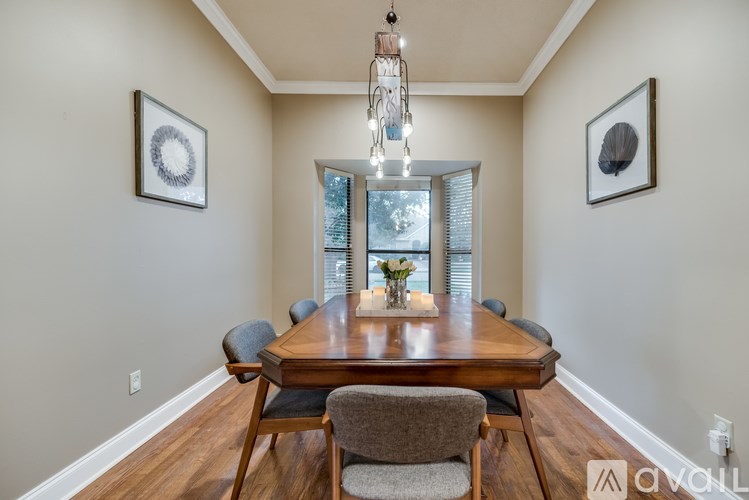A dining room with a wooden table and chairs.