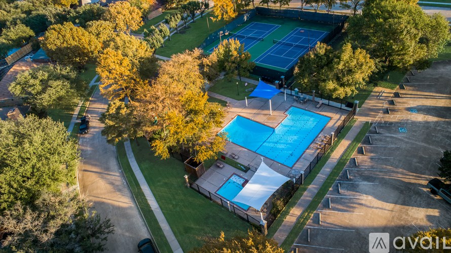 An aerial view of a tennis court surrounded by trees.