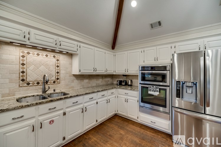 A kitchen with white cabinets and stainless steel appliances.