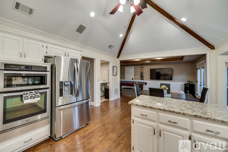 A kitchen with a refrigerator, oven, and stove top.