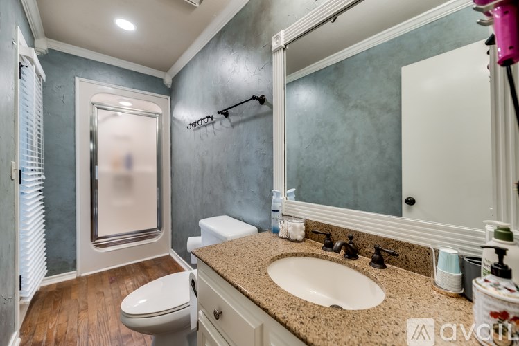 A bathroom with a toilet, sink, and mirror.