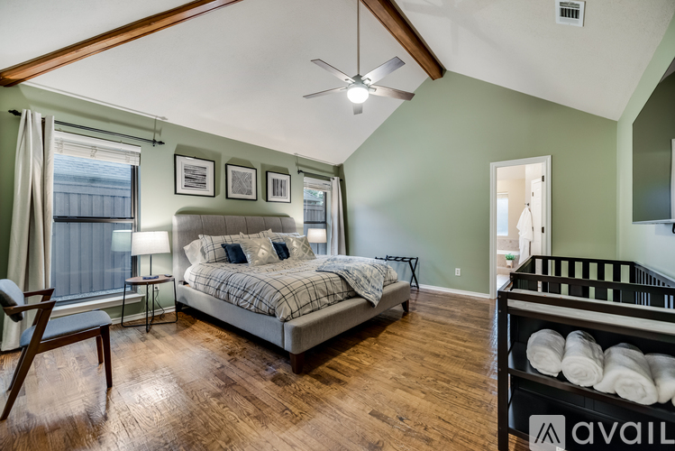 A bedroom with a large bed and a baby crib.