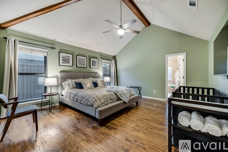 A bedroom with a large bed and a baby crib.