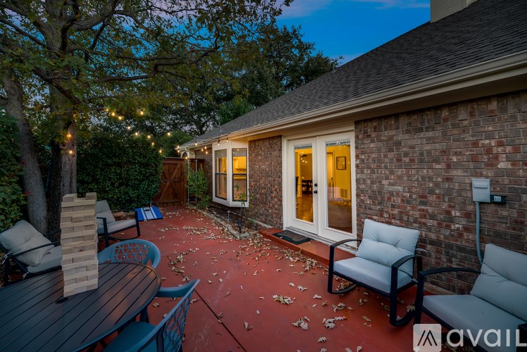 A patio with a table and chairs is set up outside a house.