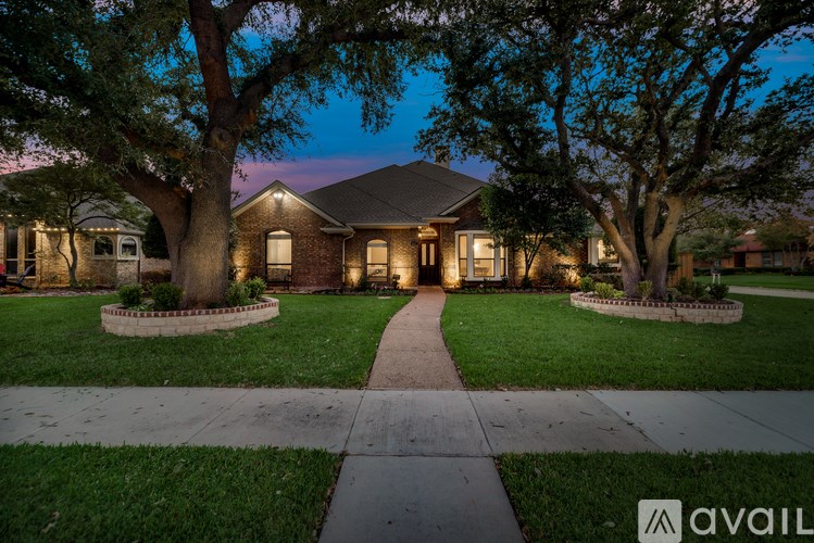 A house with a front yard and a walkway leading to the front door.