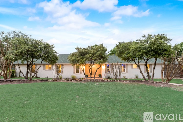 A house with a lawn and trees in front of it.