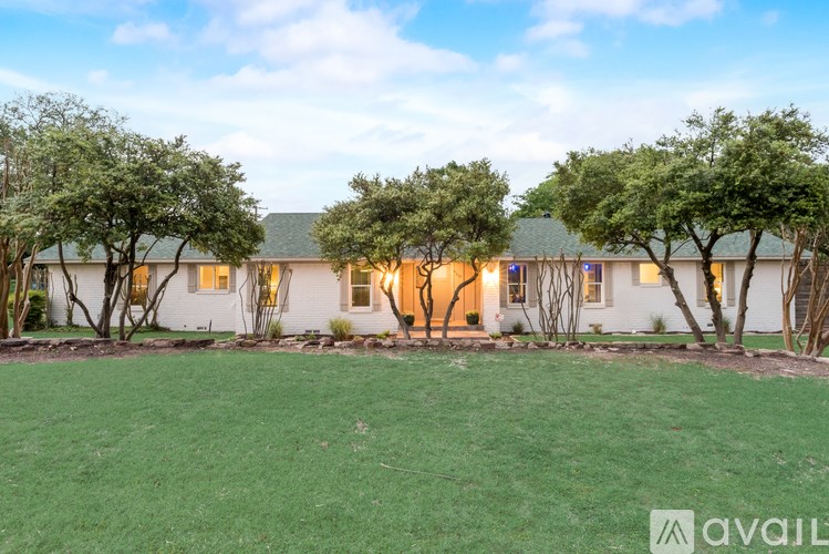 A house with a lawn and trees in front of it.