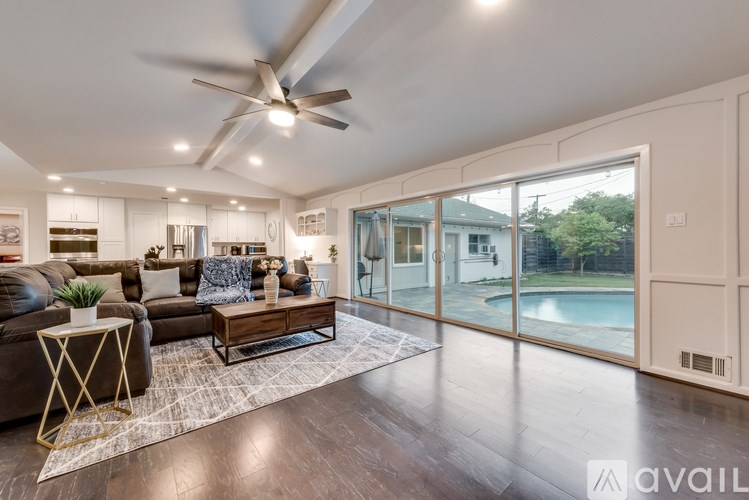 A modern living room with a pool outside the window.