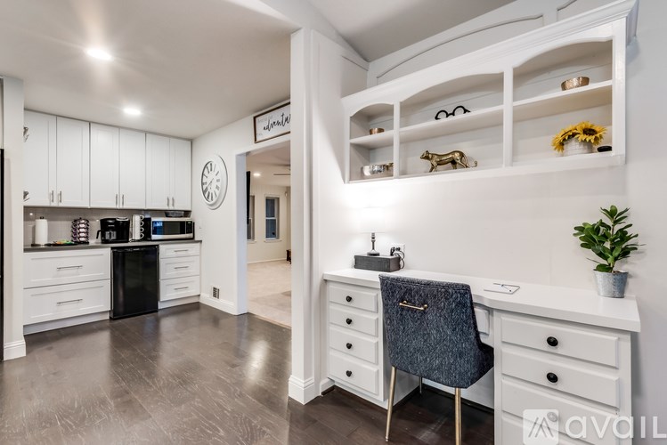 A modern kitchen with a black oven and white cabinets.
