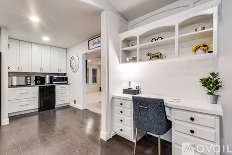 A modern kitchen with a black oven and white cabinets.