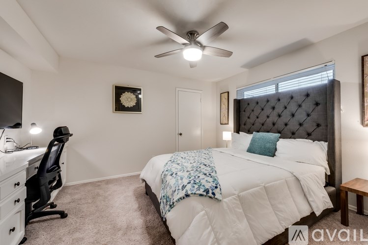 A bedroom with a large bed and a ceiling fan.