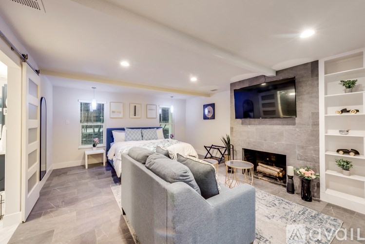 A modern living room with a grey sofa and a fireplace.