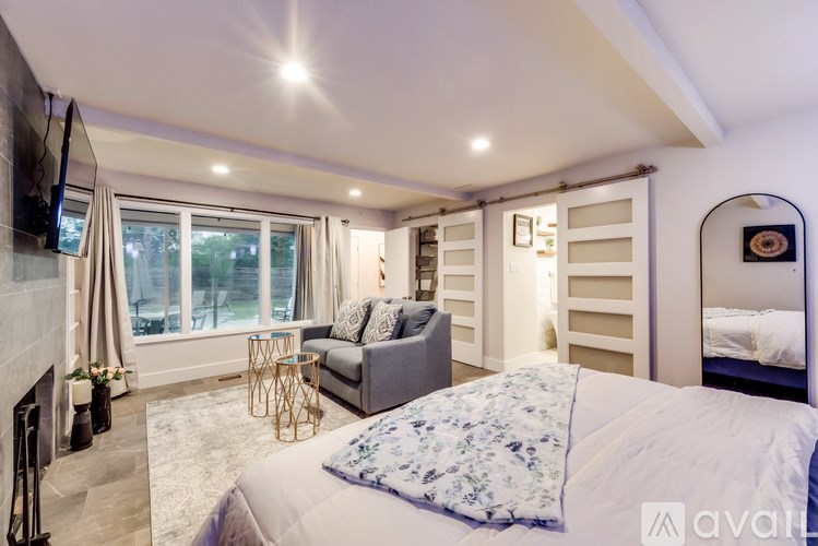 A bedroom with a large bed and a television on the wall.