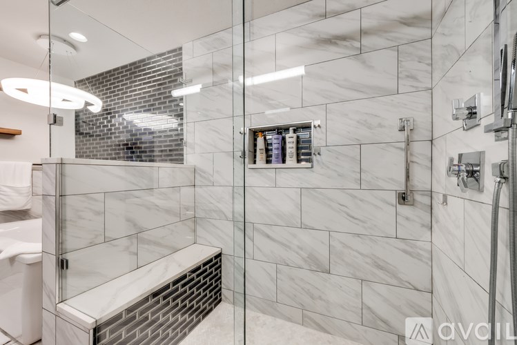 A bathroom with a walk-in shower and a bench seat.