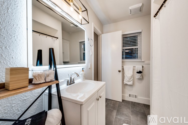 A bathroom with a white sink and a mirror above it.
