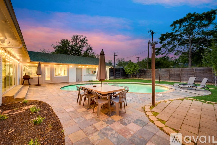 A backyard with a pool table and chairs.