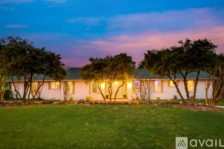 A house with a lawn and trees in front of it.
