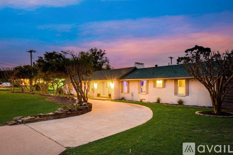 A house with a driveway and a tree in front of it.