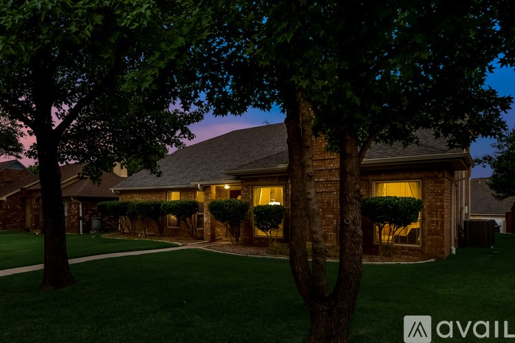 A house with a lawn and trees in front of it.