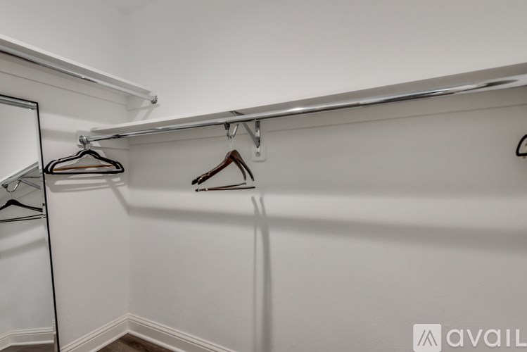 A row of clothes hangers on a white wall.