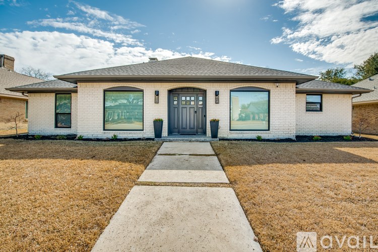 A house with a front yard and a walkway leading to the front door.