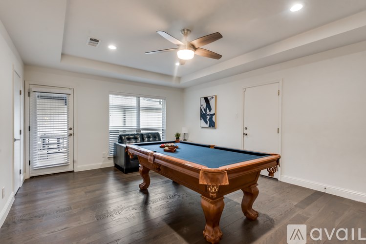 A pool table in a room with a ceiling fan.